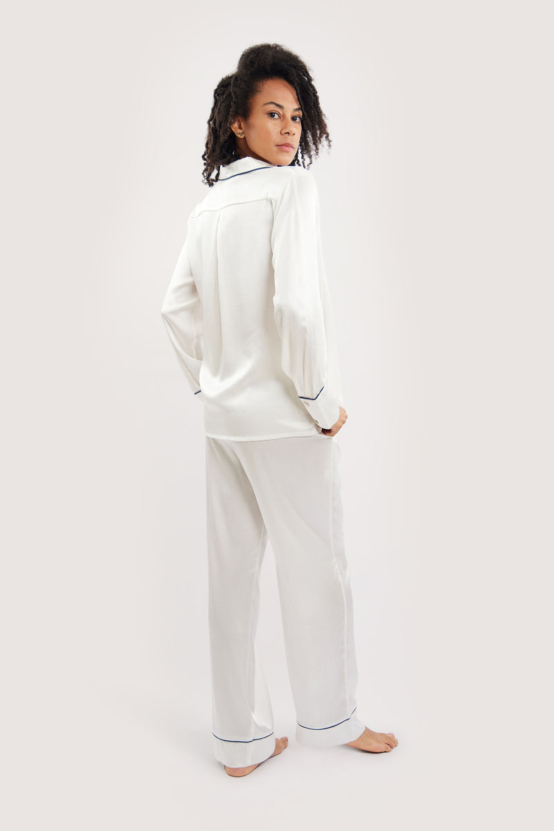 Our model wearing long-sleeve Rose Ivory silk pyjama set on white background - sideway look - version one