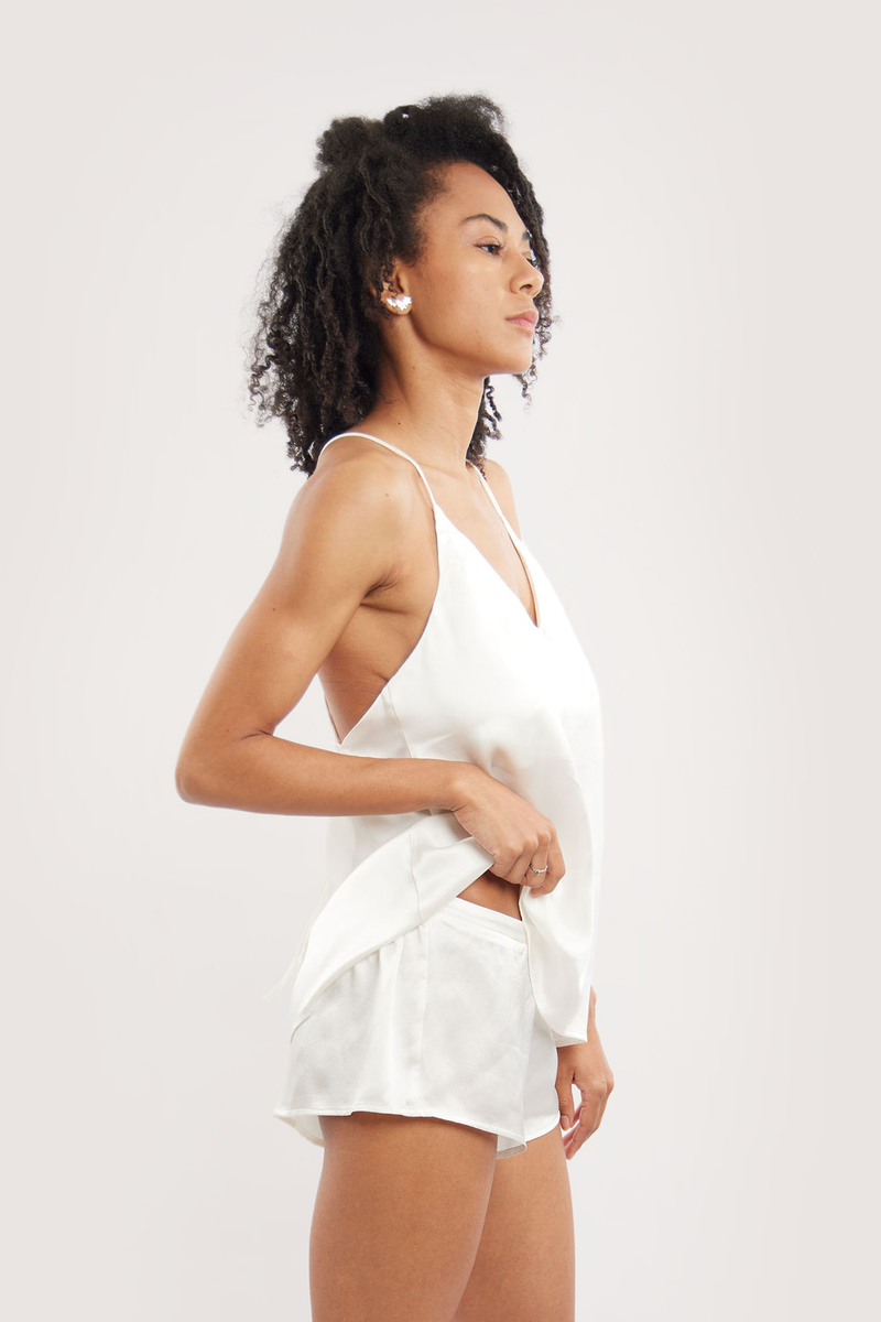 Our model wearing Dee Ivory silk camisole set on white background - side look